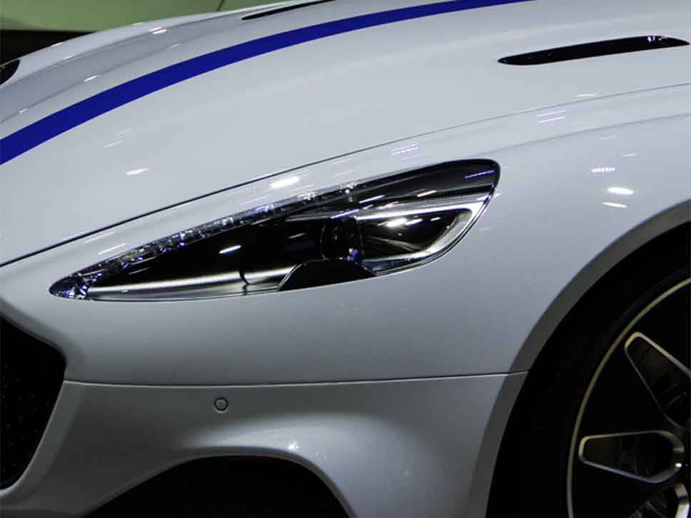 White Aston Martin with blue stripe on bonnet