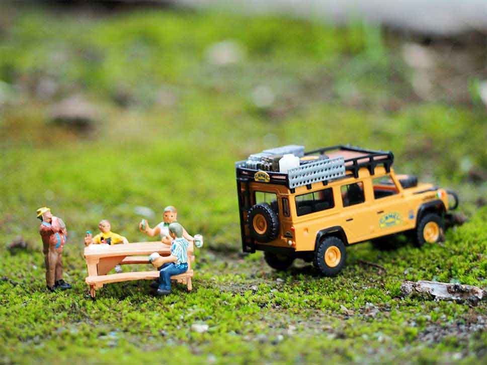 Toy Jeep parked next to friends having a drink on a bench