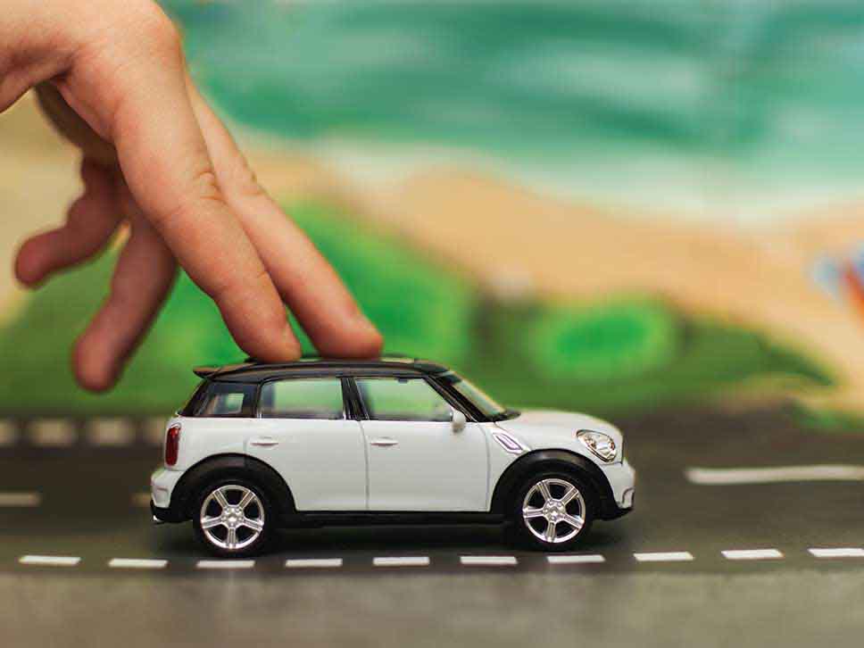 Toy MINI being pushed by two fingers