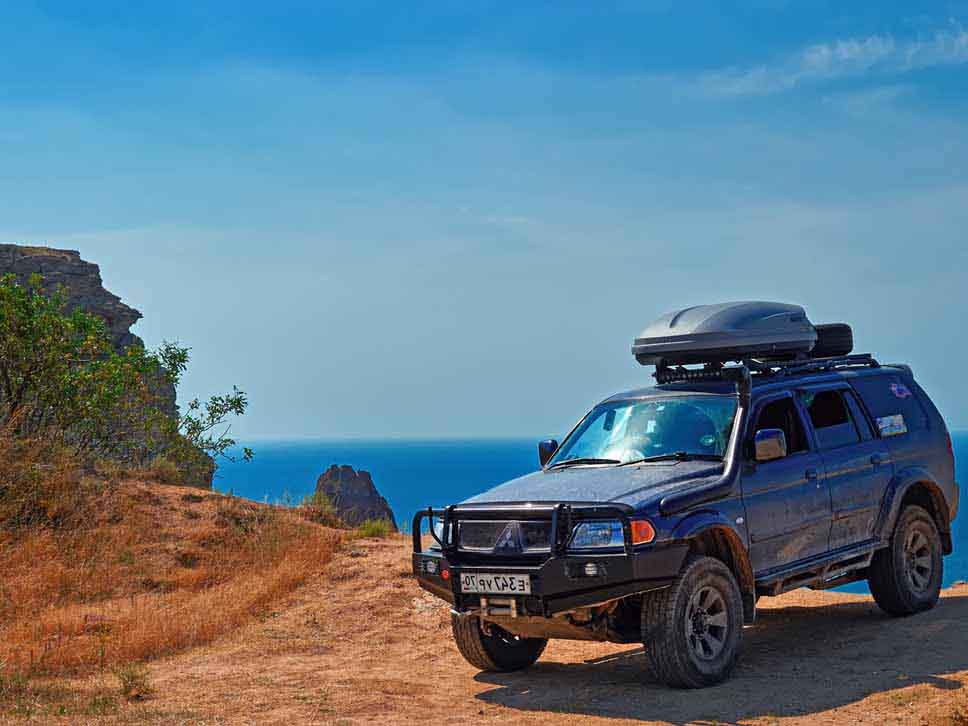 Mitsubishi off roader parked on clif edge