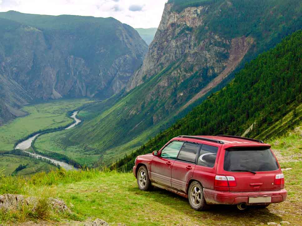 Subaru off roader in mountains overlooking beautiful scenery