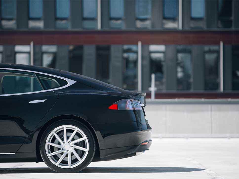 Rear side profile of a black Tesla
