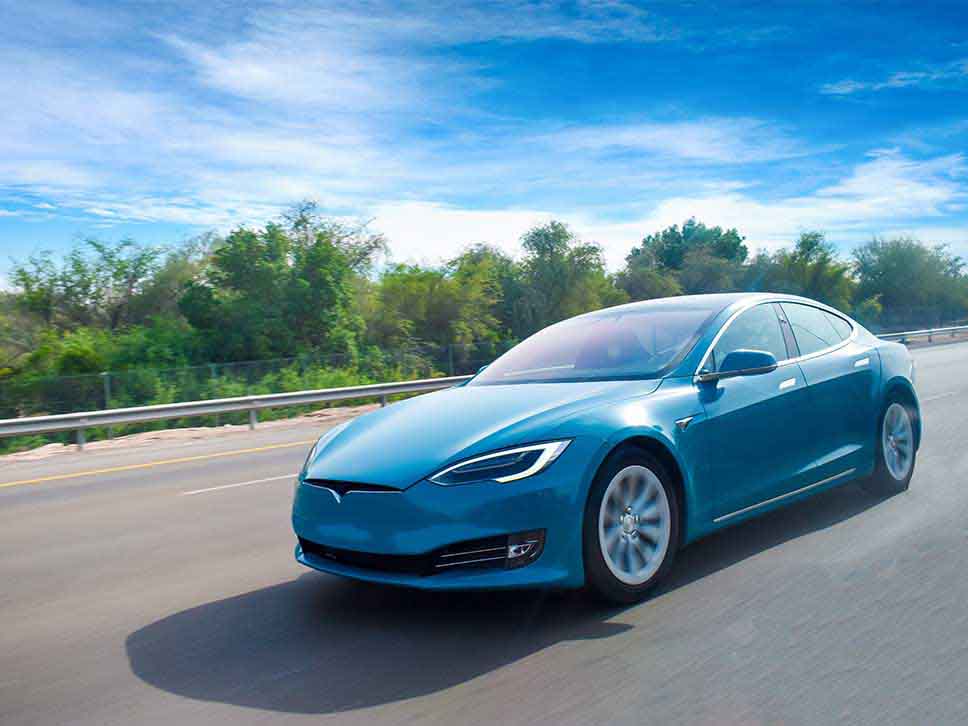 Blue Tesla crusing on a motorway
